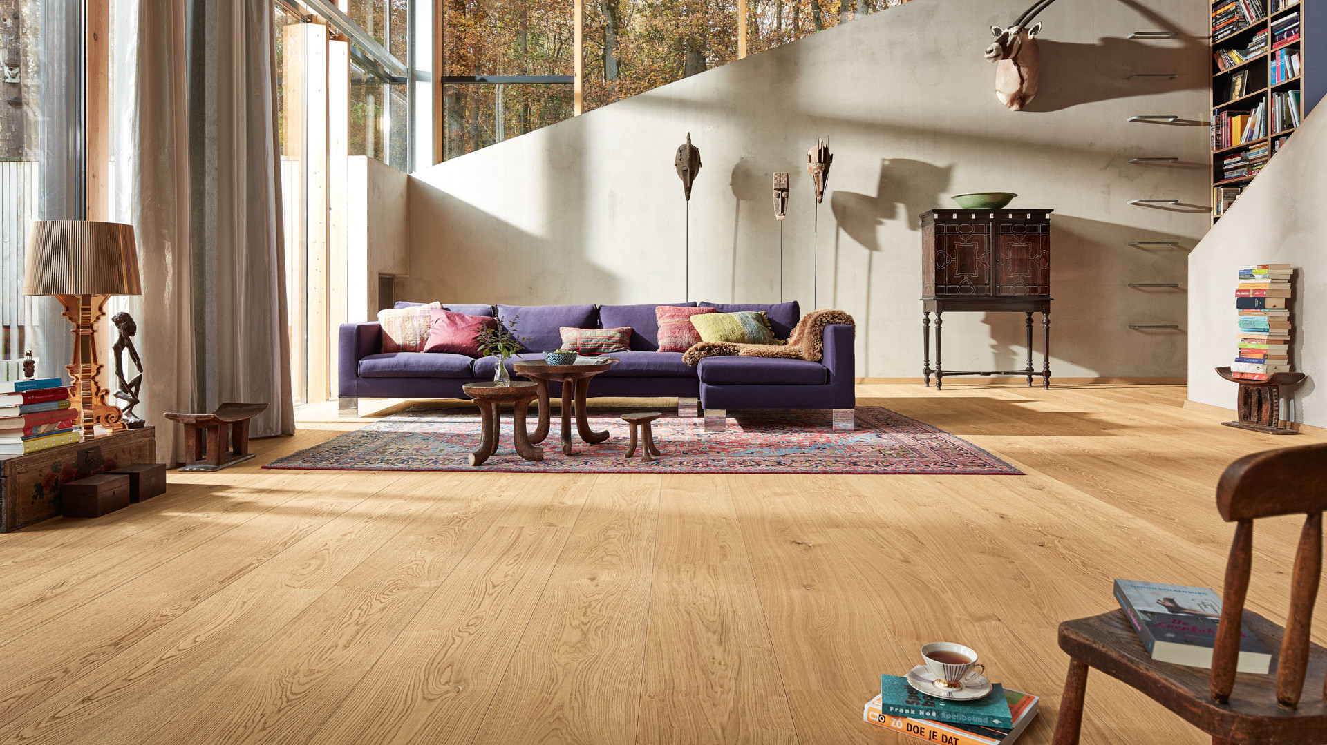 Lindura-Holzboden Eiche natur pure in einem hellen Wohnzimmer mit lila Sofa
