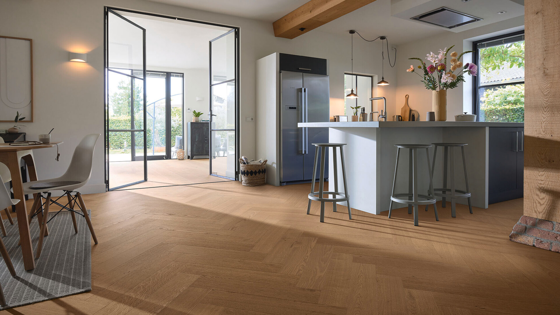 Lindura-Holzboden von MEISTER im Fischgrätformat in einer offenen Küche mit Lofttür