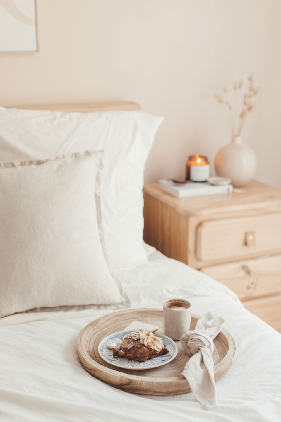 Holztablett mit Frühstück auf einem Bett
