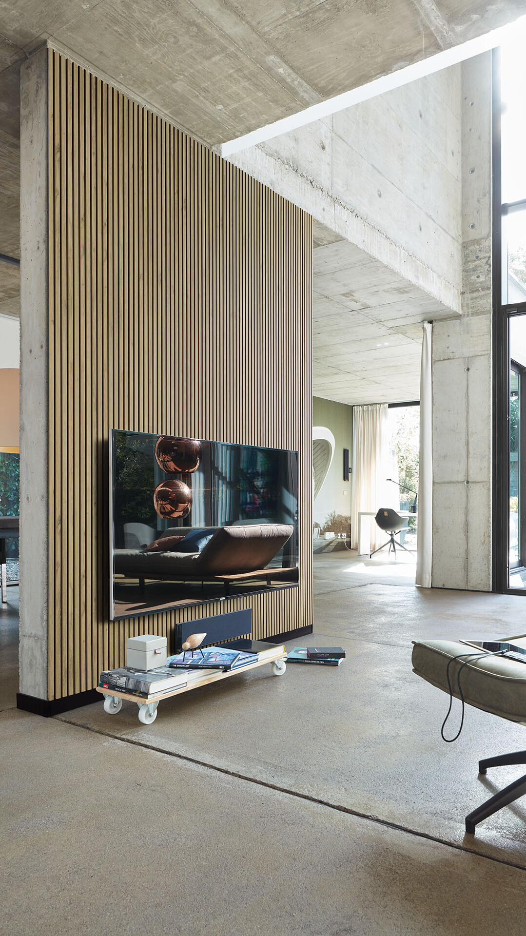 Voll im Trend: Akustikpaneele Holz auf Filz an einer Wand hinter dem Fernseher