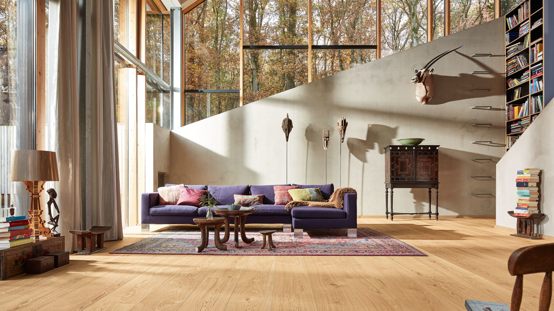 Lindura-Holzboden Eiche natur pure in einem hellen Wohnzimmer mit lila Sofa