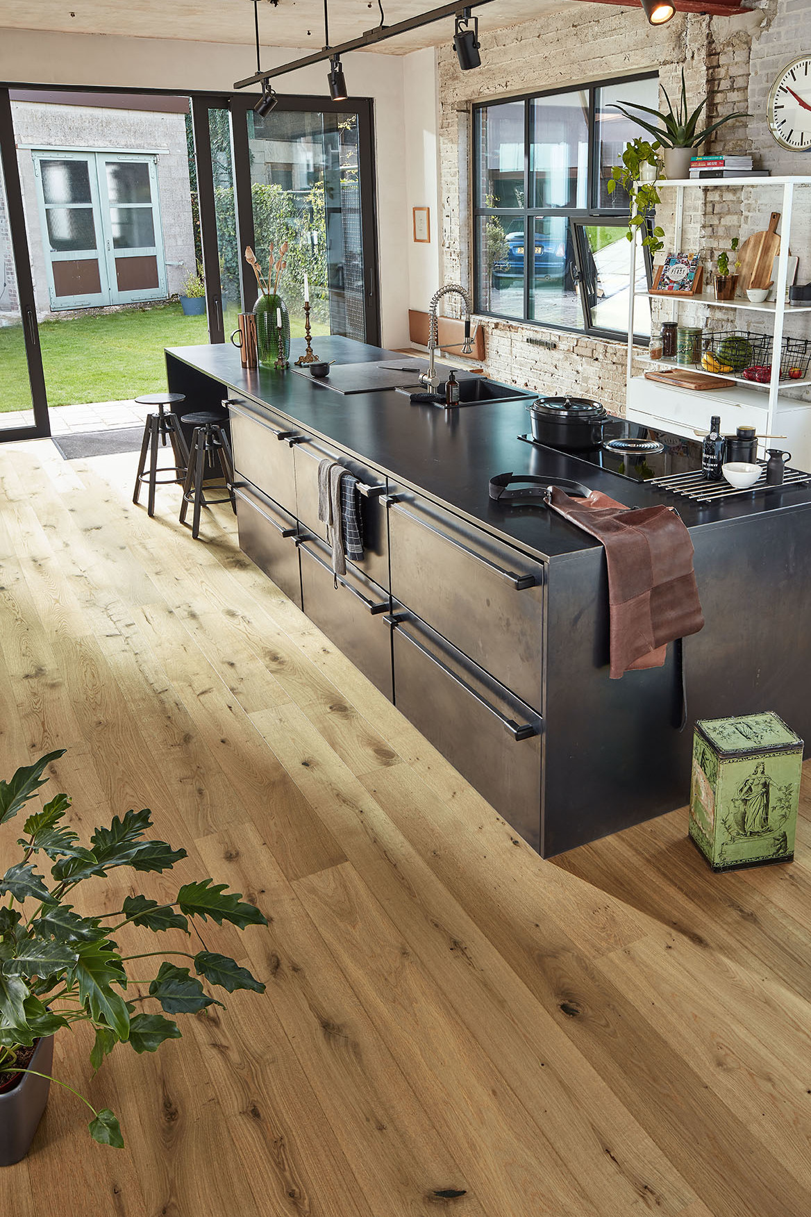 Naturgeölte Parkettdielen in vitaler Sortierung unter einem schwarzen Küchenblock