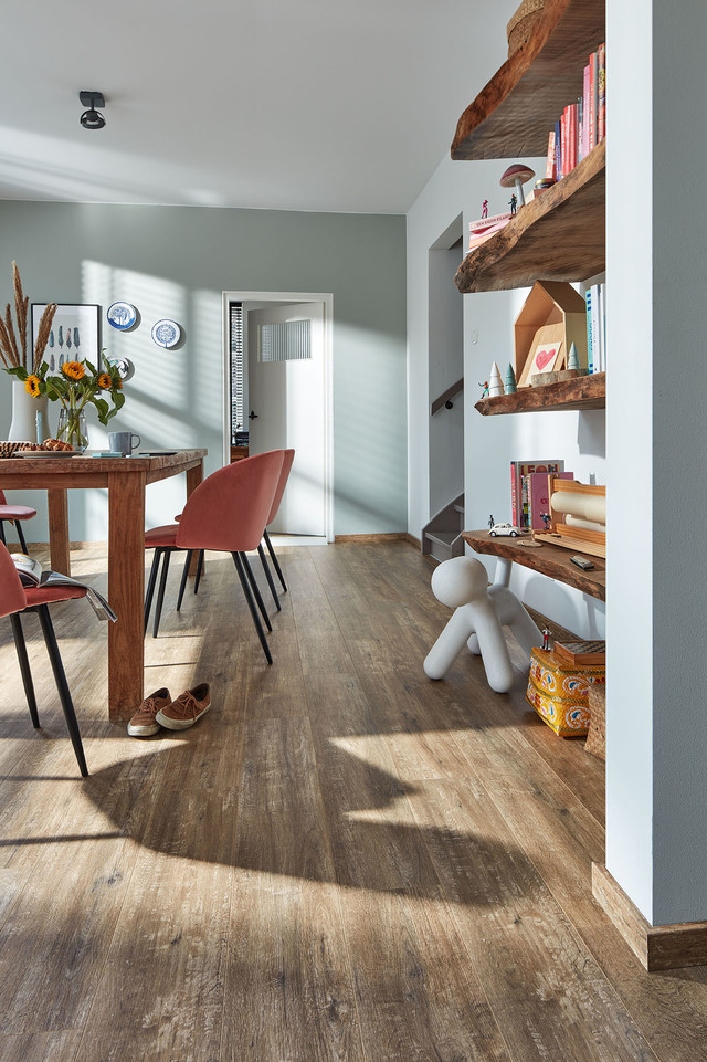 Laminatboden gibt es in authentischen Holzoptiken, Steinnachbildungen und kreativen Designs. Laminatboden in Holzoptik unter einem Esstisch mit Stühlen