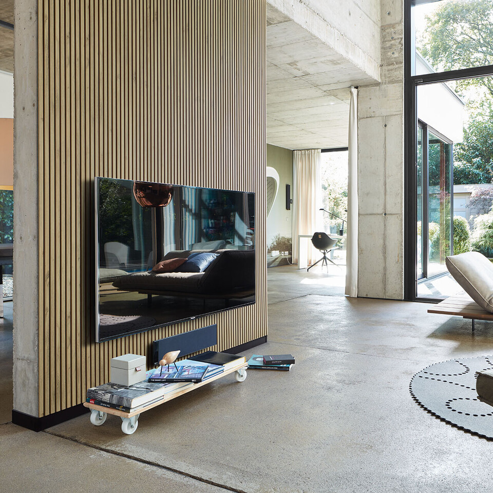 Akustikpaneele Holz auf einer Wand als Raumtrenner hinter dem Fernseher