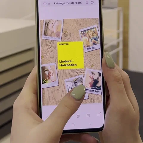 Kurzvideo zeigt wie jemand auf dem Smartphone durch einen digitalen Blätterkatalog zu Lindura-Holzboden blättert