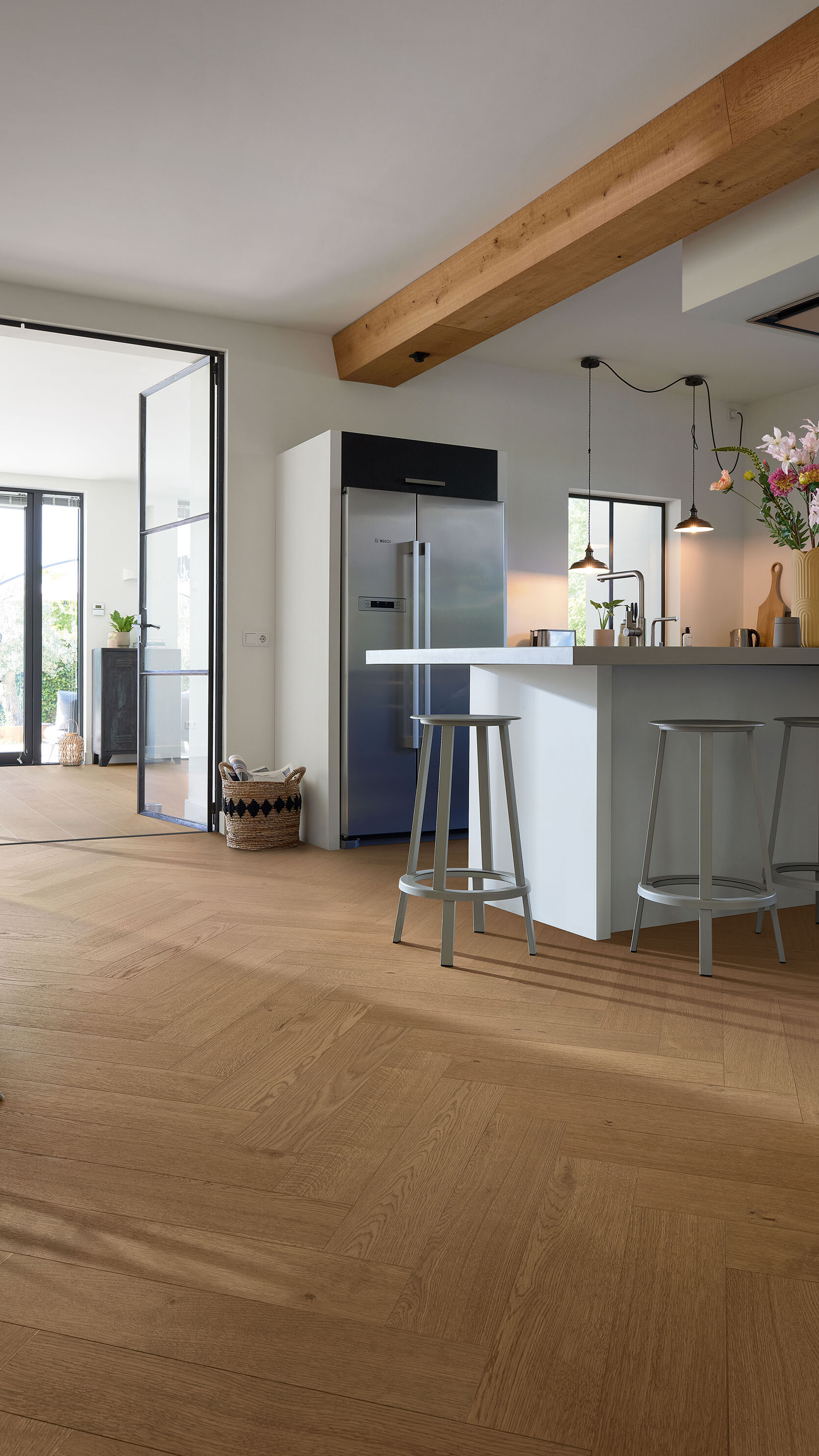 Lindura-Holzboden von MEISTER im Fischgrätformat in einer offenen Küche mit Lofttür